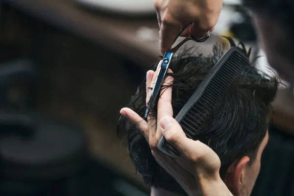 Obrazy Fryzjer podczas męskiego strzyżenia w barbershopie na wymiar