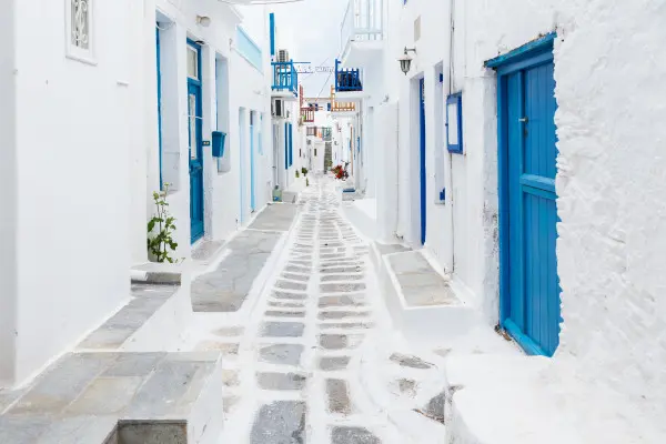 Obrazy Mykonos – biała uliczka z niebieskimi okiennicami na wymiar