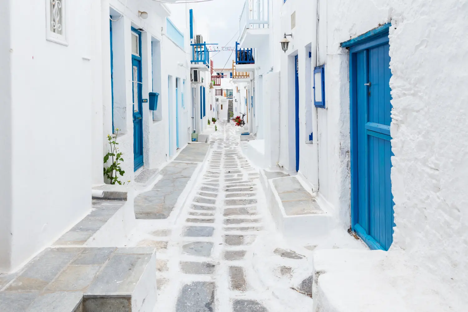 Fototapeta Mykonos – biała uliczka z niebieskimi okiennicami